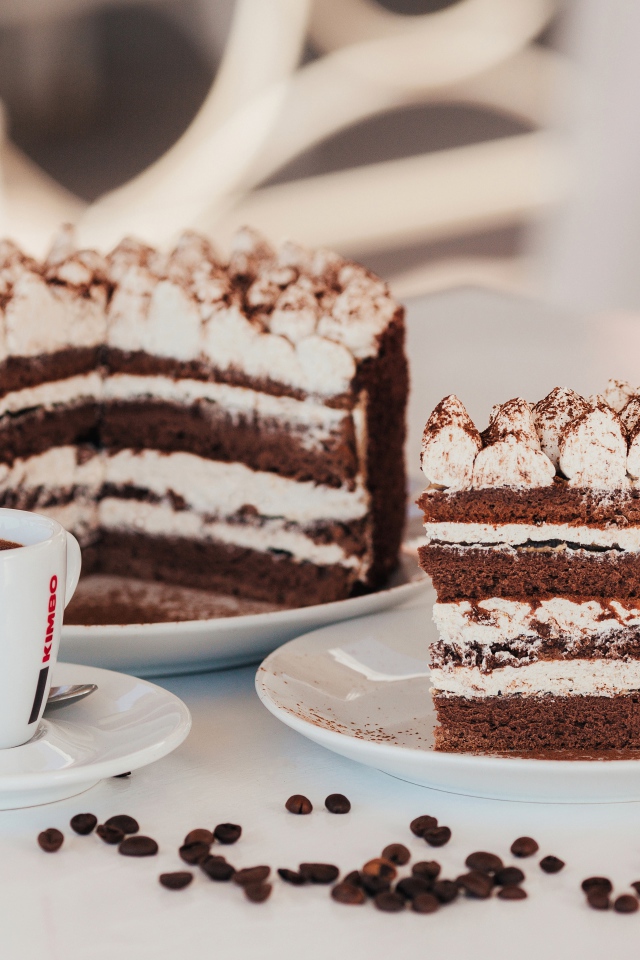 Аппетитный торт с чашкой кофе на столе