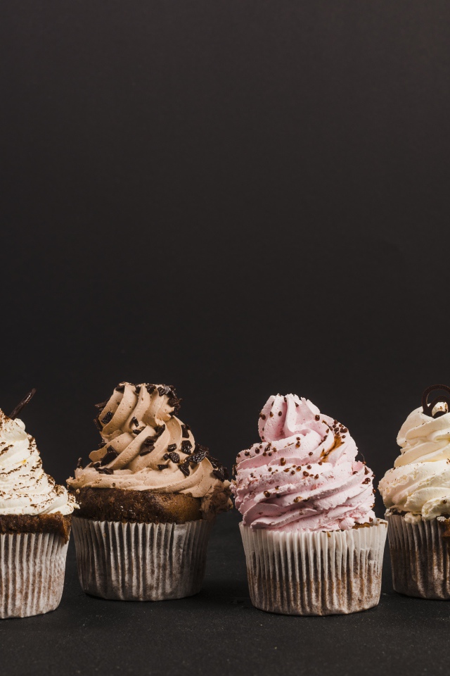 Аппетитные кексы с кремом на сером фоне