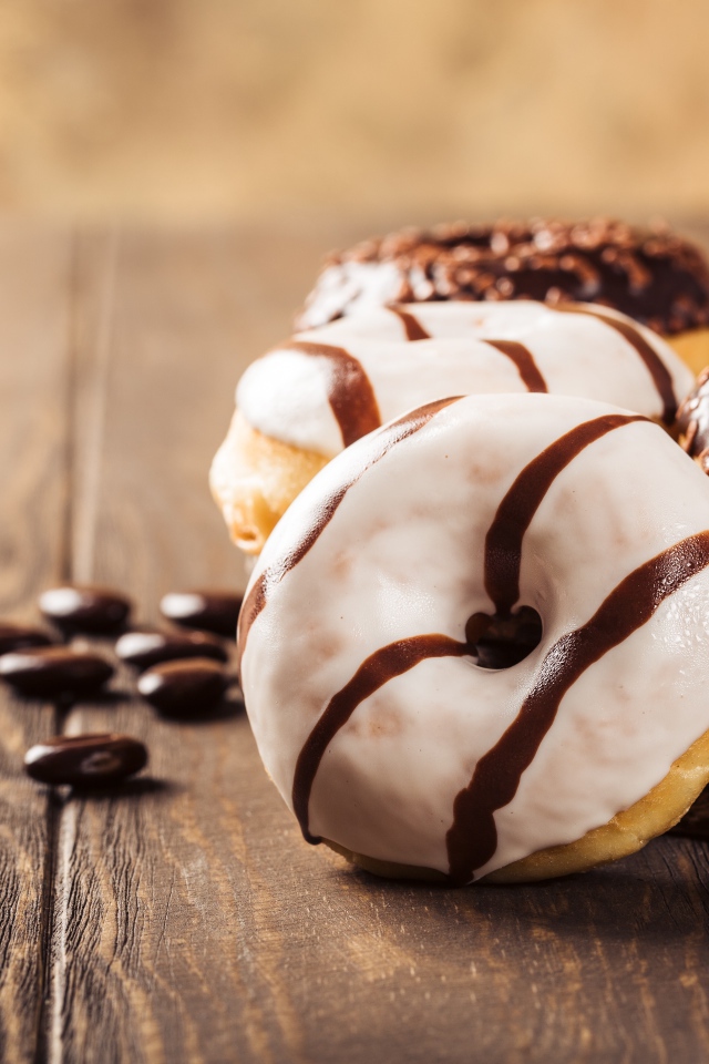 Аппетитные сладкие пончики с глазурью на столе