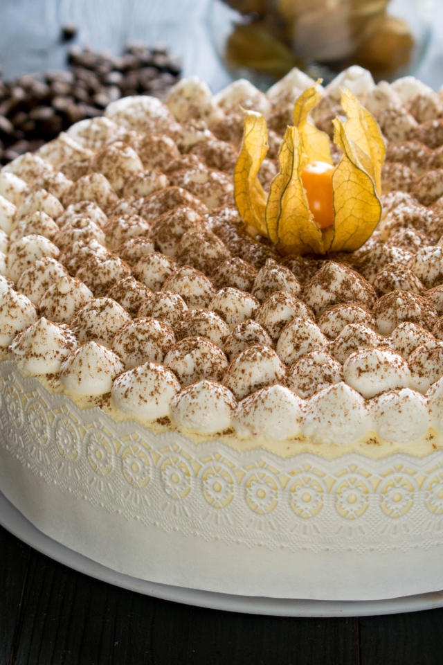 Красивый праздничный торт с цветком физалиса на столе с кофе