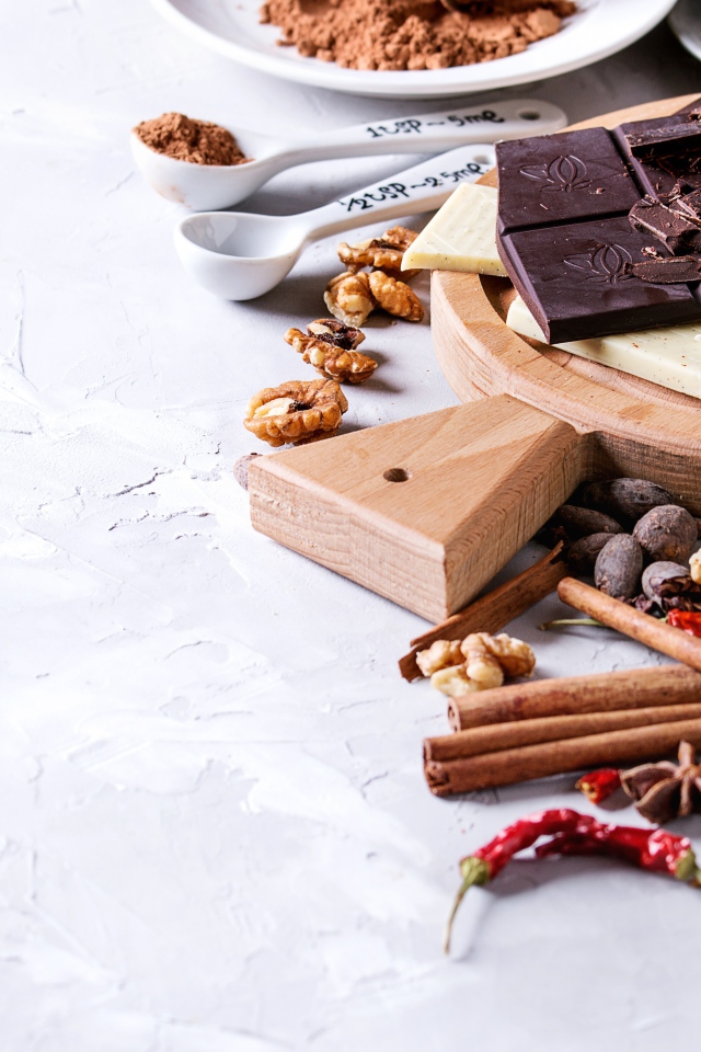 Черный и молочный шоколад на столе с орехами