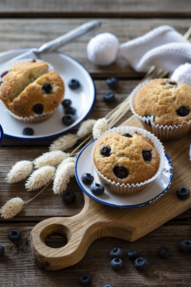 Кексы с черникой на столе с колосьями и кофе
