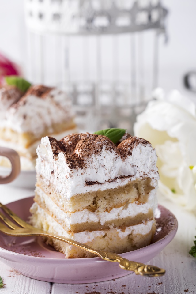 Пирожное на столе с кофе и цветами 