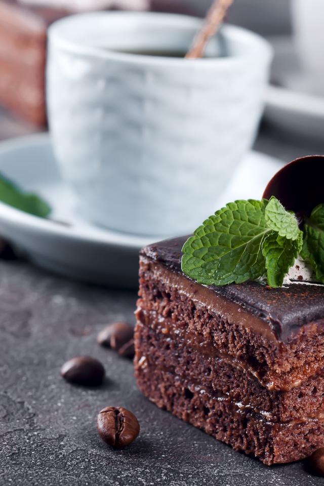 Шоколадное пирожное на столе с чашкой кофе