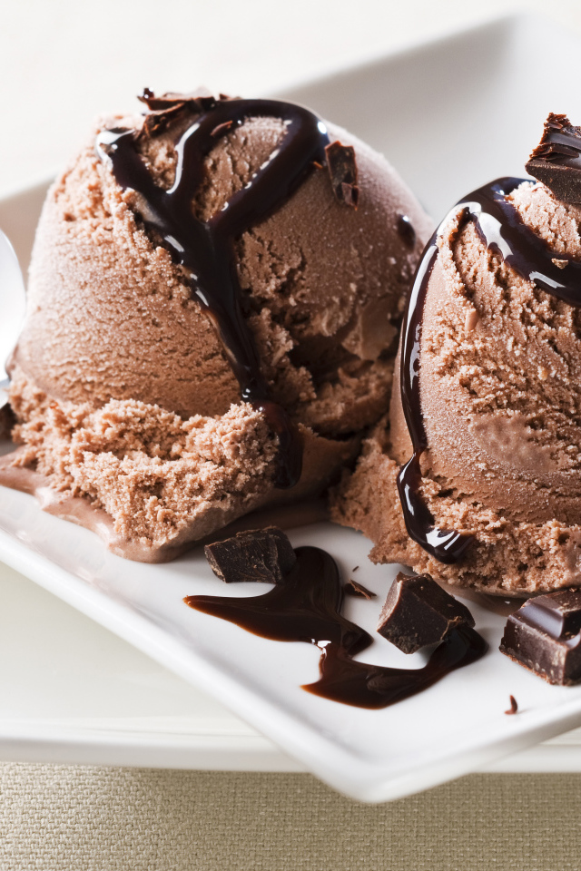 Шарики шоколадного мороженого на белой тарелке