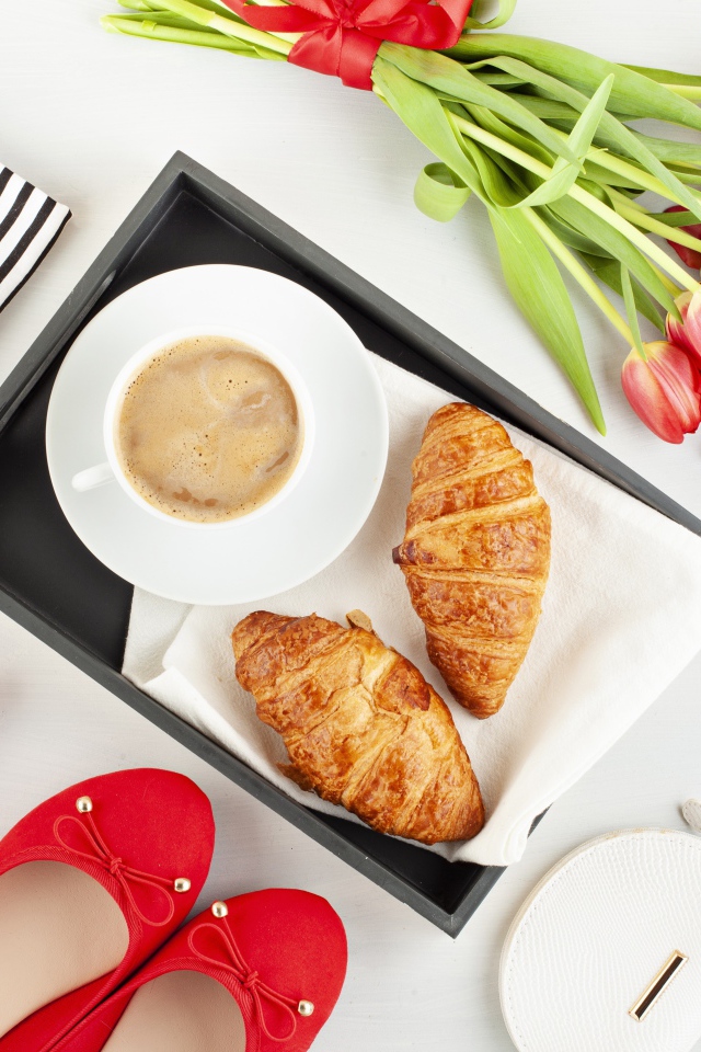 Кофе и круассаны на столе с букетом для любимой