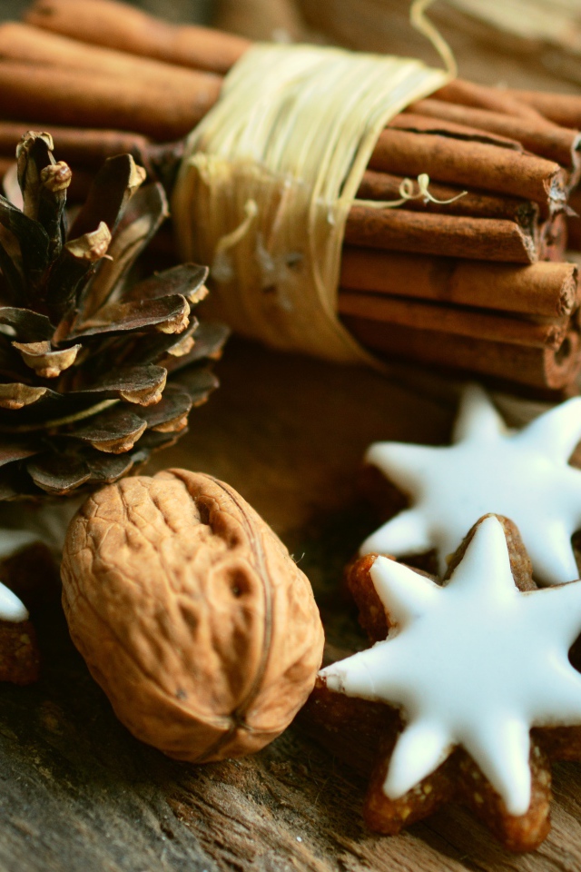 Печенье, орехи, палочки корицы и еловые шишки на деревянном столе