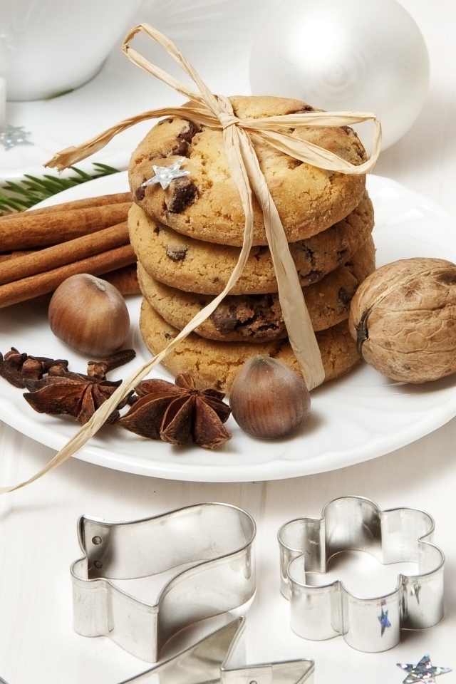 Печенье на тарелке с орехами и корицей на столе с игрушками 