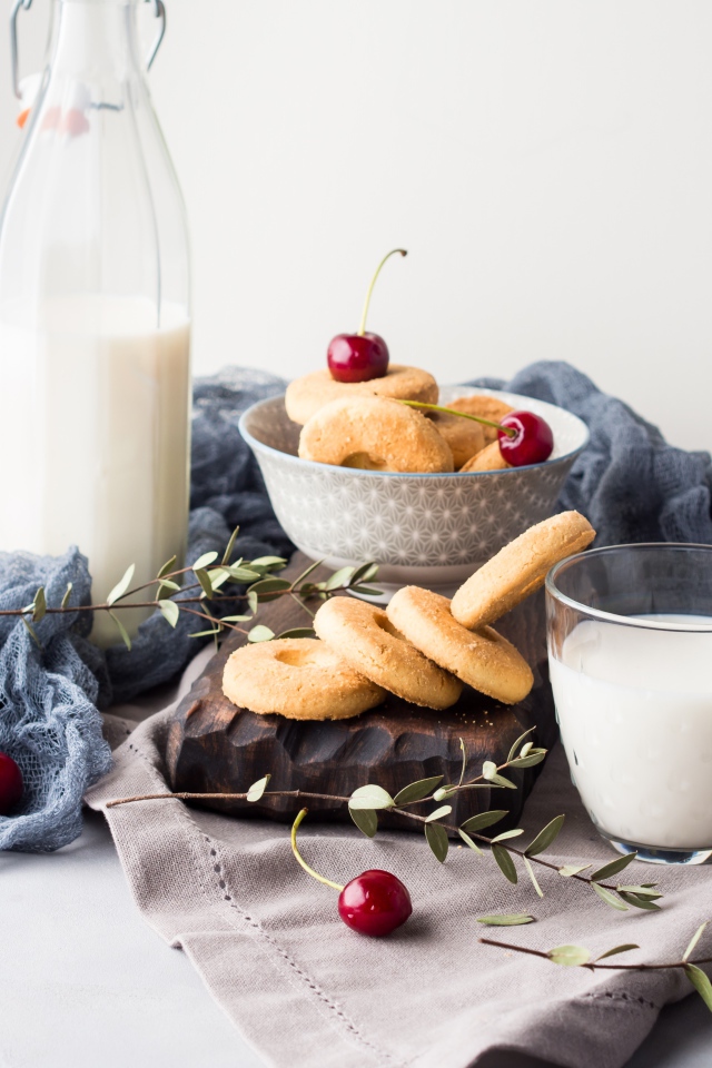 Печенье на столе с молоком и черешней