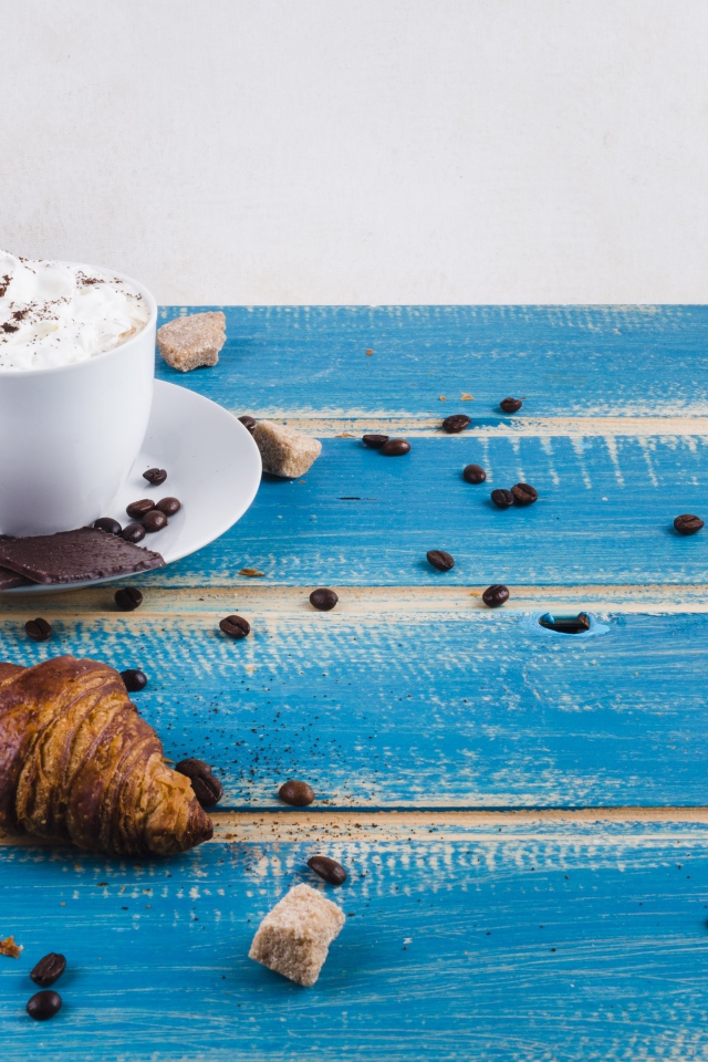 Круассаны на столе с напитком и шоколадом