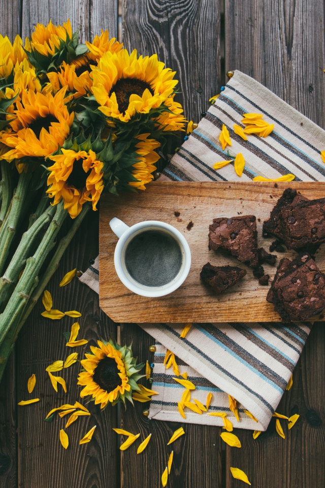 Чашка кофе на столе с пирогом и букетом подсолнухов