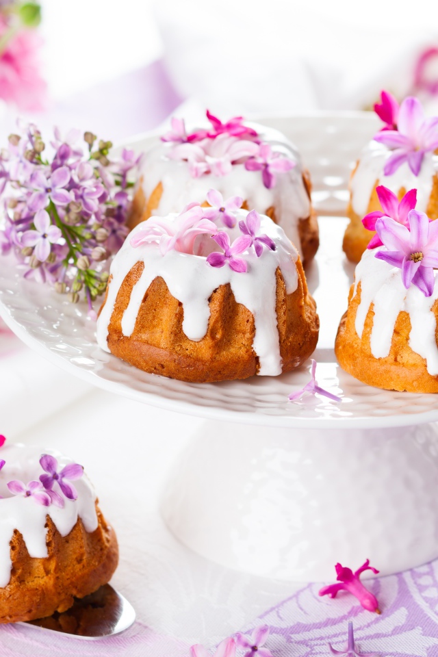 Кексы с глазурью на подносе с цветами сирени 