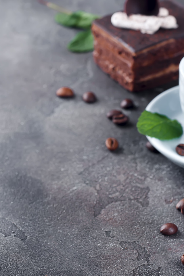 Аппетитное шоколадное пирожное на сером столе с чашкой кофе