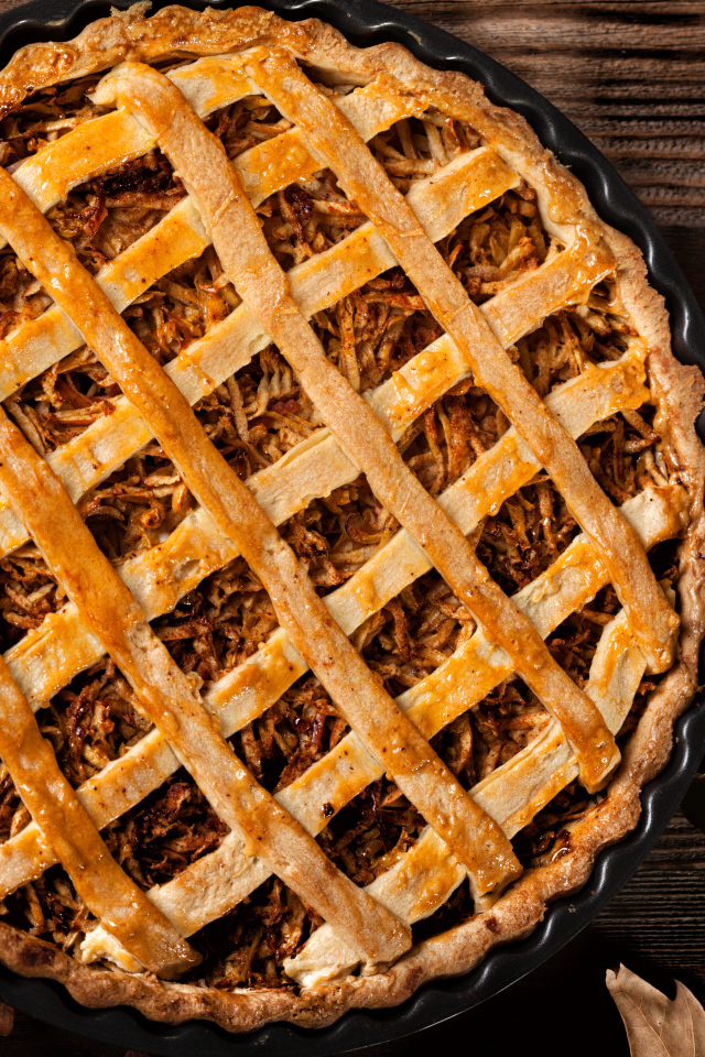 Вкусный горячий пирог на столе с яблоками 