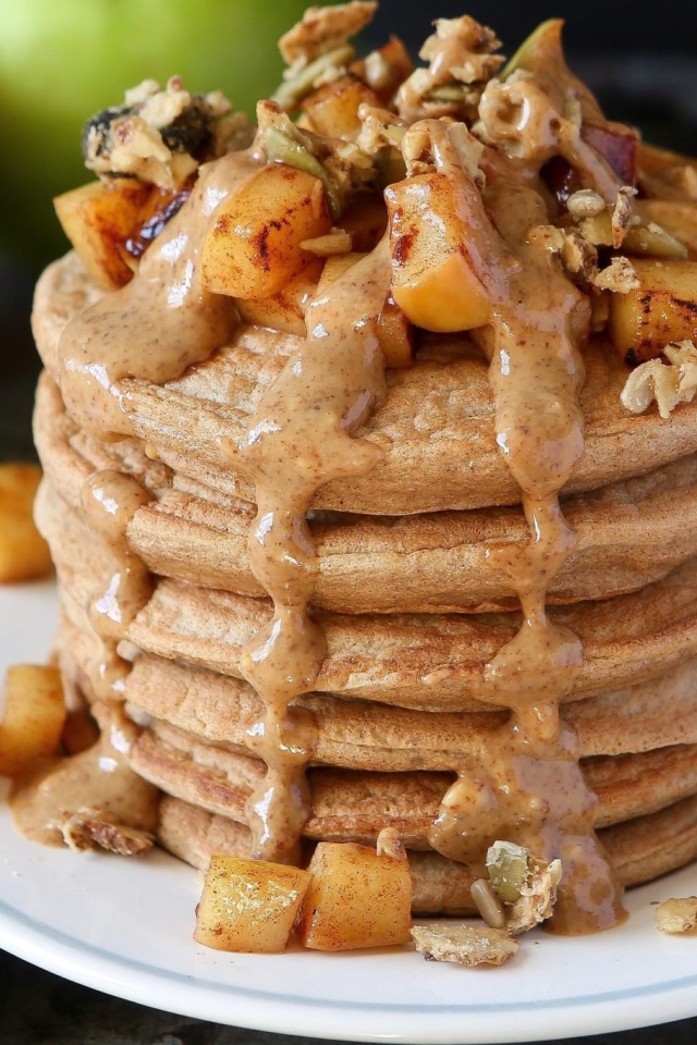 Вкусные оладьи с соусом и фруктами на столе с корицей