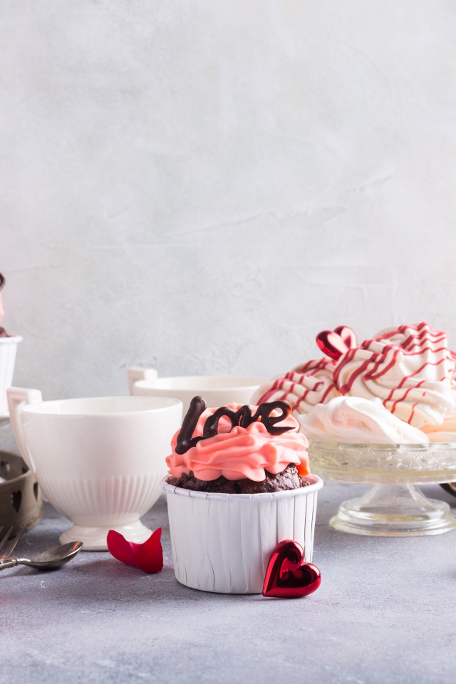 Аппетитные сладкие кексы на столе с розами