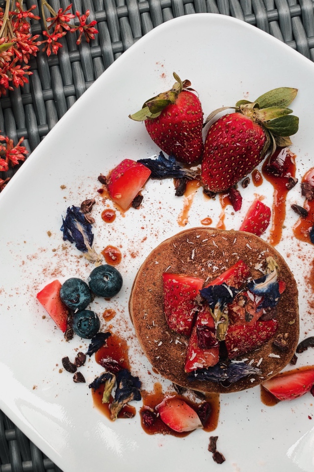 Десерт на белой тарелке с ягодами 