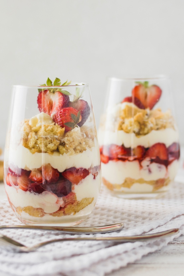 Десерт с клубникой в стеклянных стаканах на столе 