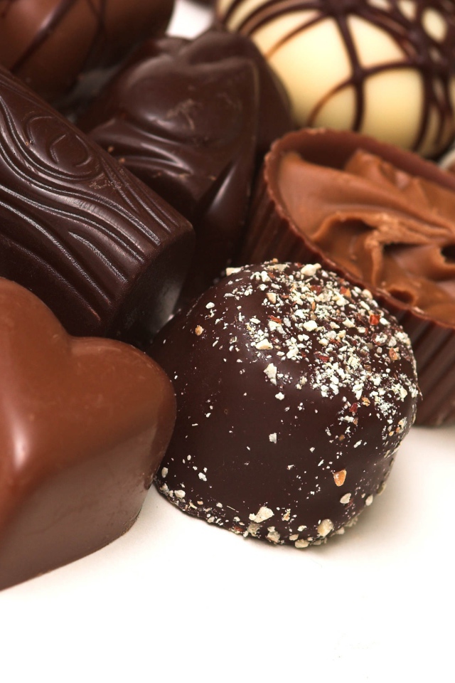 Разные шоколадные конфеты на белом фоне 