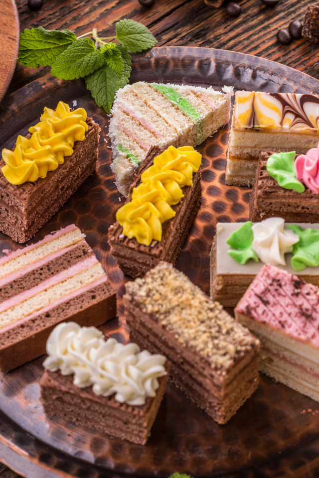 Разные вкусные пирожные на подносе 