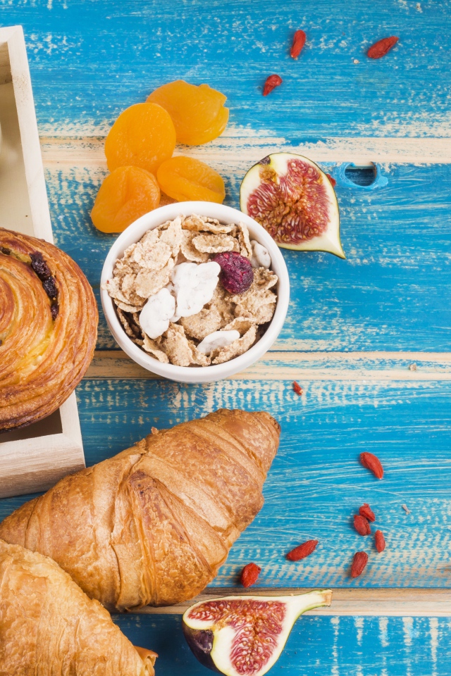 Свежая выпечка, молоко и мюсли на завтрак на столе