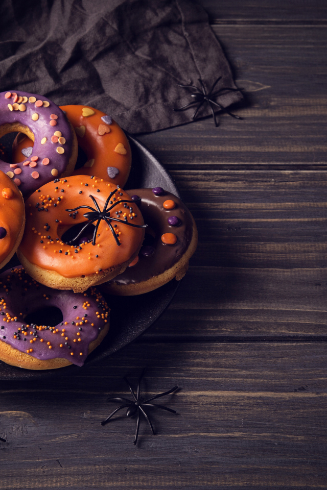 Пончики с глазурью на столе угощение на Хэллоуин 