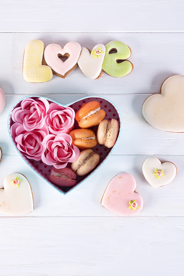 Печенье в форме сердца на столе с коробкой с десертом макарун