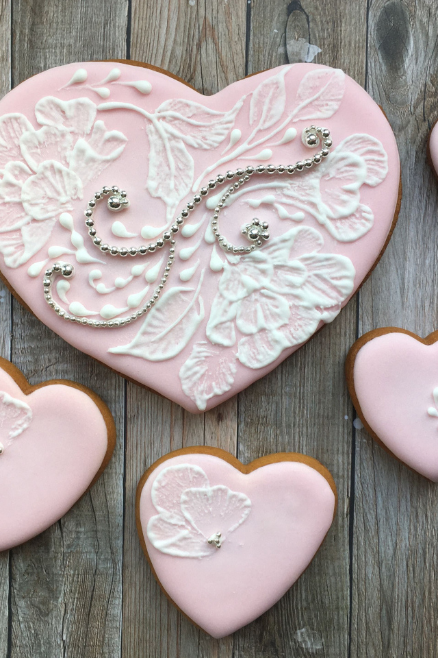 Печенье в форме сердца с розовой глазурью на столе