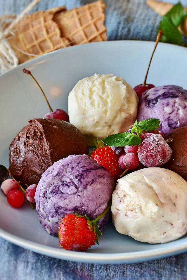 Шарики фруктового мороженого на тарелке со свежими ягодами