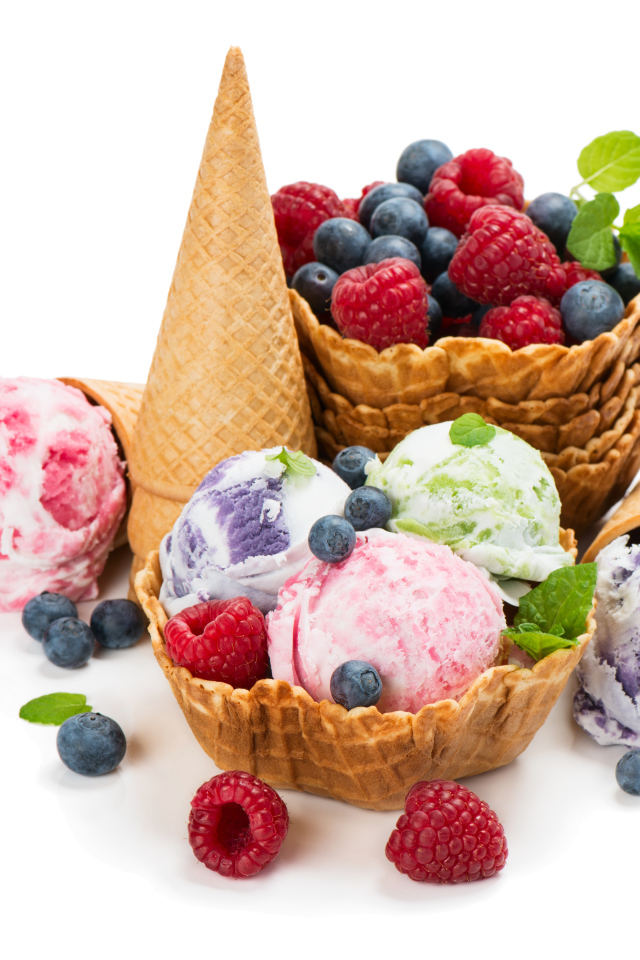 Шарики мороженого на белом фоне с вафлями и ягодами 