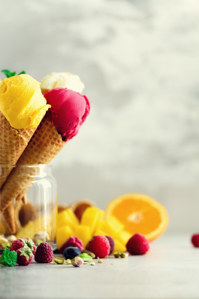 Фруктовое мороженое в вафельных рожках на столе с ягодами и фруктами