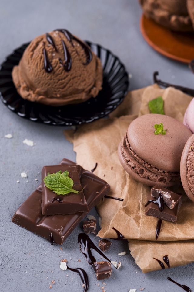 Печенье макарун на серой поверхности с мороженым и шоколадом