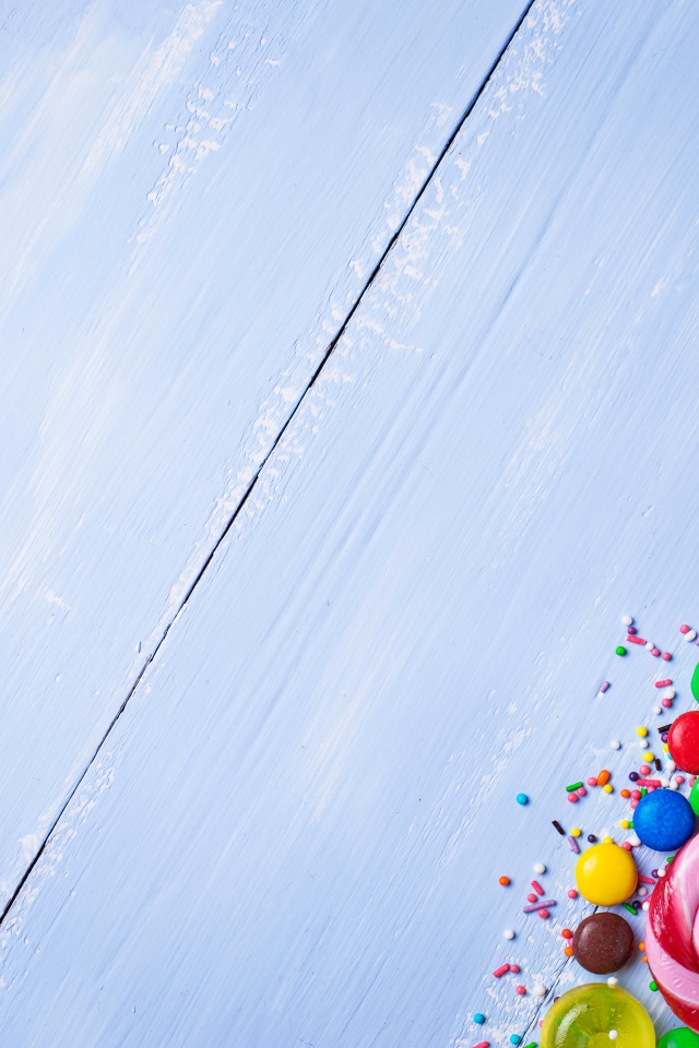 Разноцветные конфеты на голубом столе