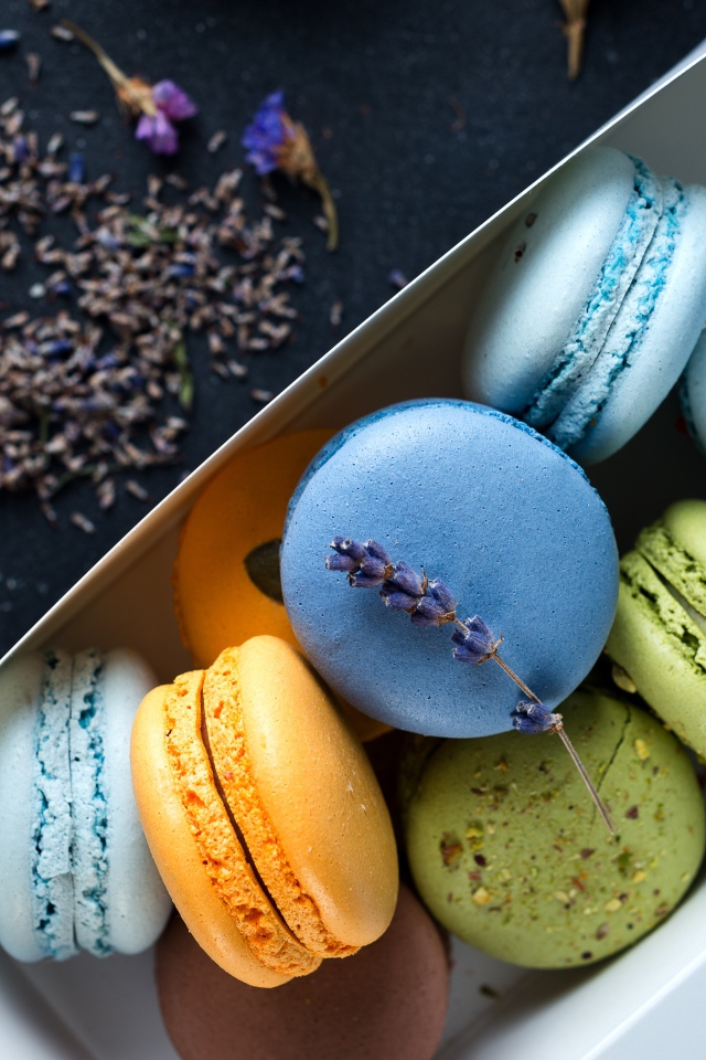 Разноцветный десерт макарон в коробке на столе с лавандой