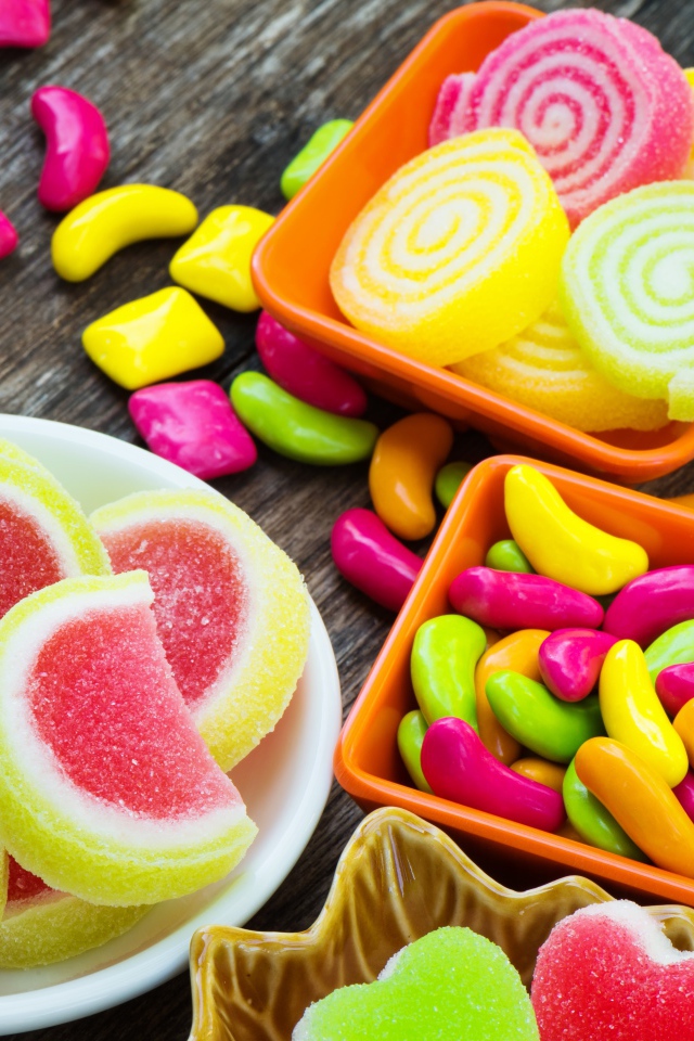 Разноцветный мармелад с конфетами на деревянном столе