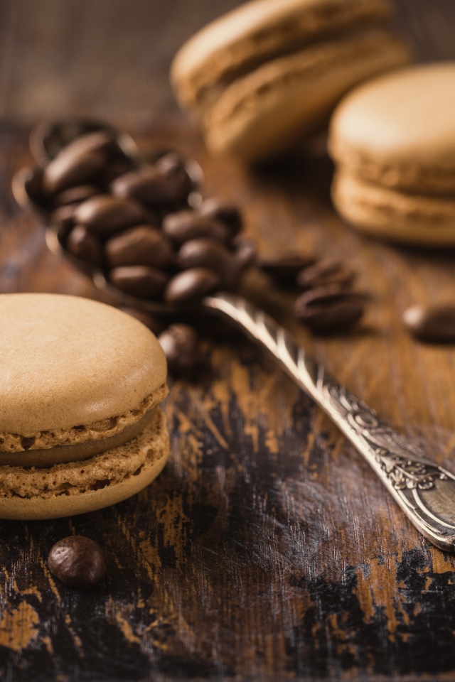 Печенье макарон на столе с ложкой и кофейными зернами