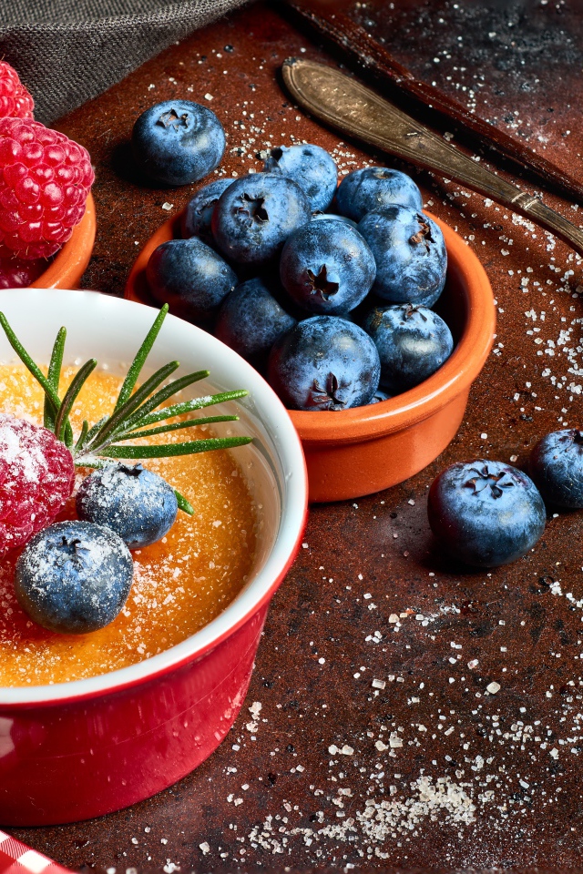 Пудинг на столе с ягодами малины и черники