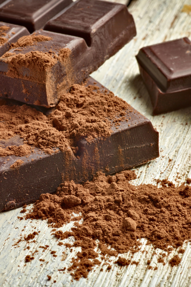 Куски шоколада с какао на деревянном столе 