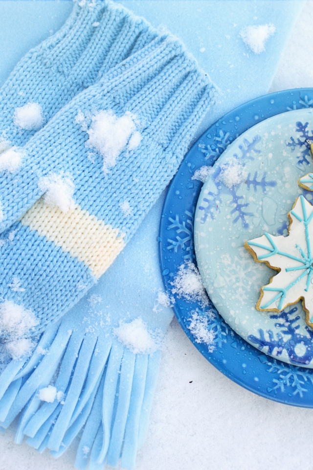 Печенье снежинки на снегу с шарфом и рукавицами