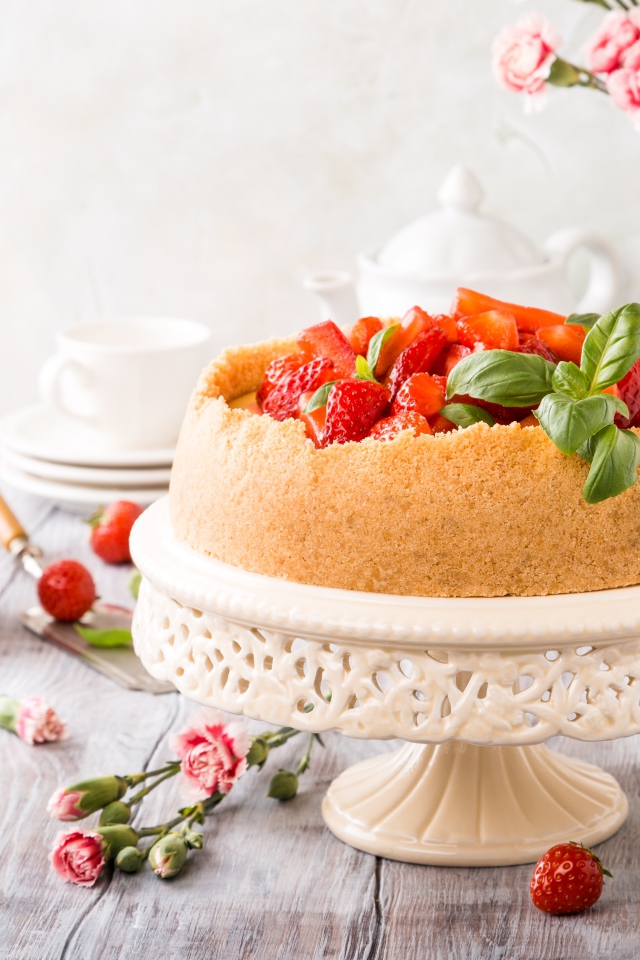 Песочный пирог с клубникой на столе с цветами гвоздики