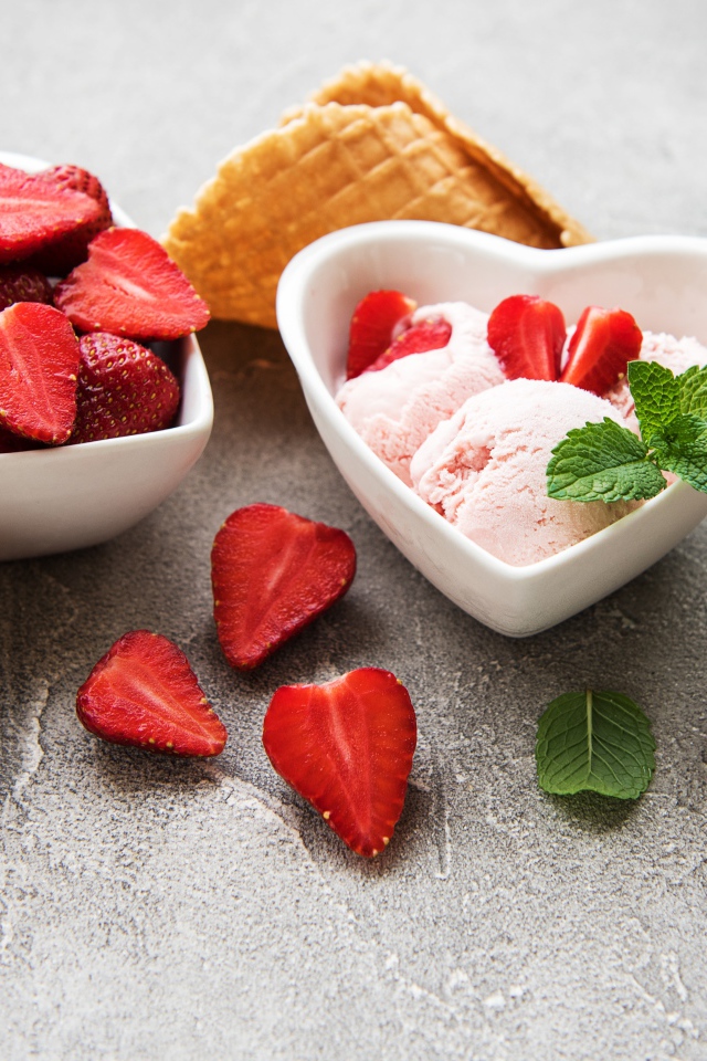 Вкусное мороженое на столе с клубникой и вафельными рожками