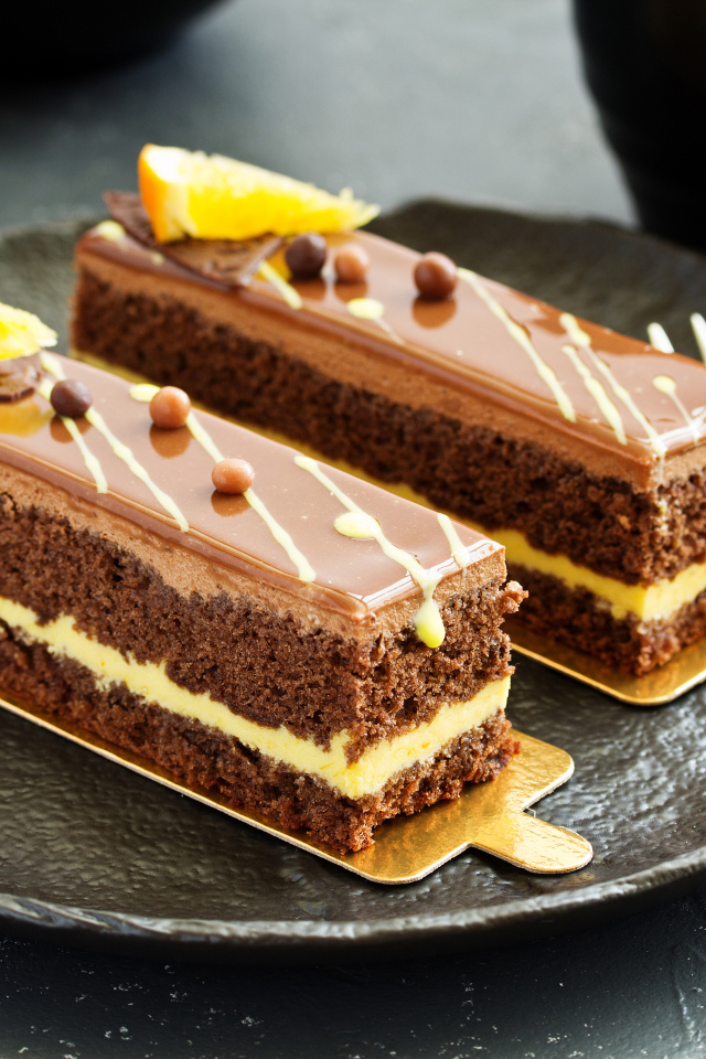 Два вкусных шоколадных пирожный на большой тарелке с вилкой