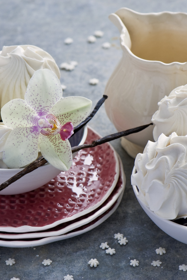 Белый зефир на столе с цветком орхидеи