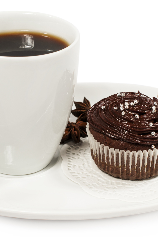 Чашка кофе на белой тарелке с кексом и корицей