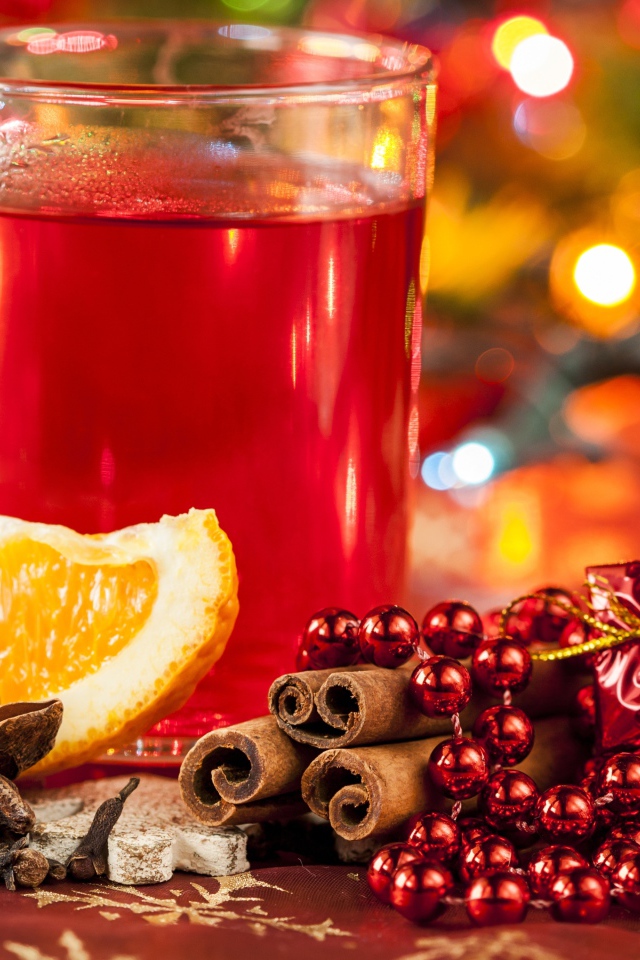 Чашка горячего чая на столе с корицей, бадьяном и кусочком апельсина 