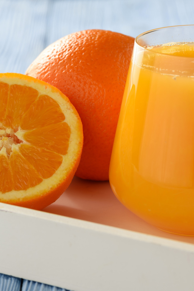 Стакан апельсинового сока на столе с апельсином 
