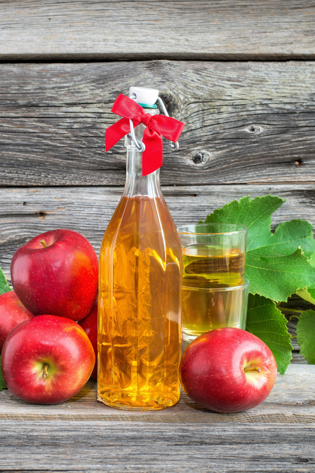 Яблочный сок на столе с красными яблоками