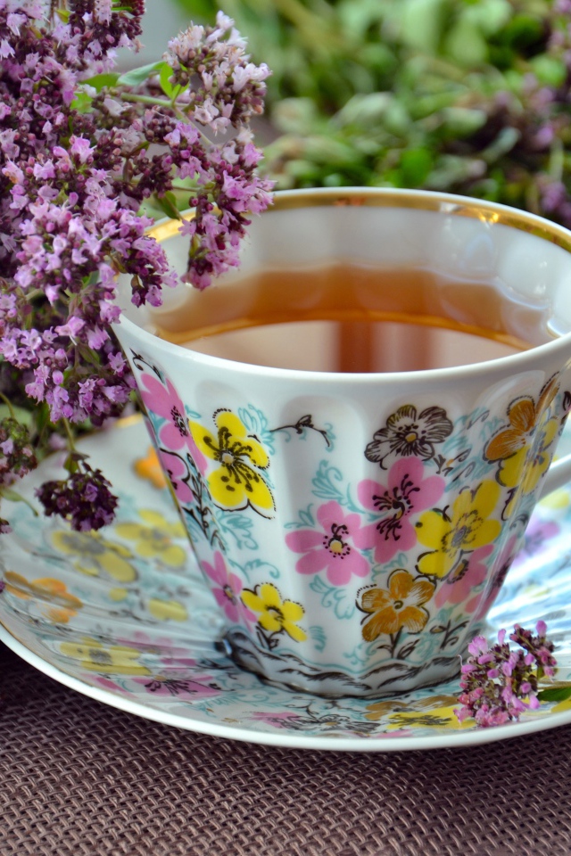 Красивая чашка чаю с цветами мяты на столе