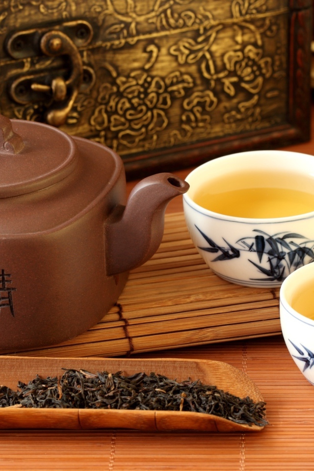 Китайский чайник на столе с чашками