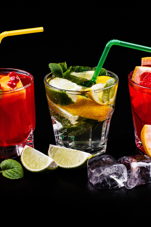 Цитрусовые алкогольные коктейли на черном фоне с фруктами